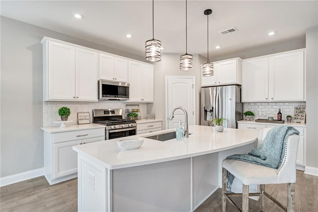 a kitchen with a center island a counter space stainless steel appliances and cabinets