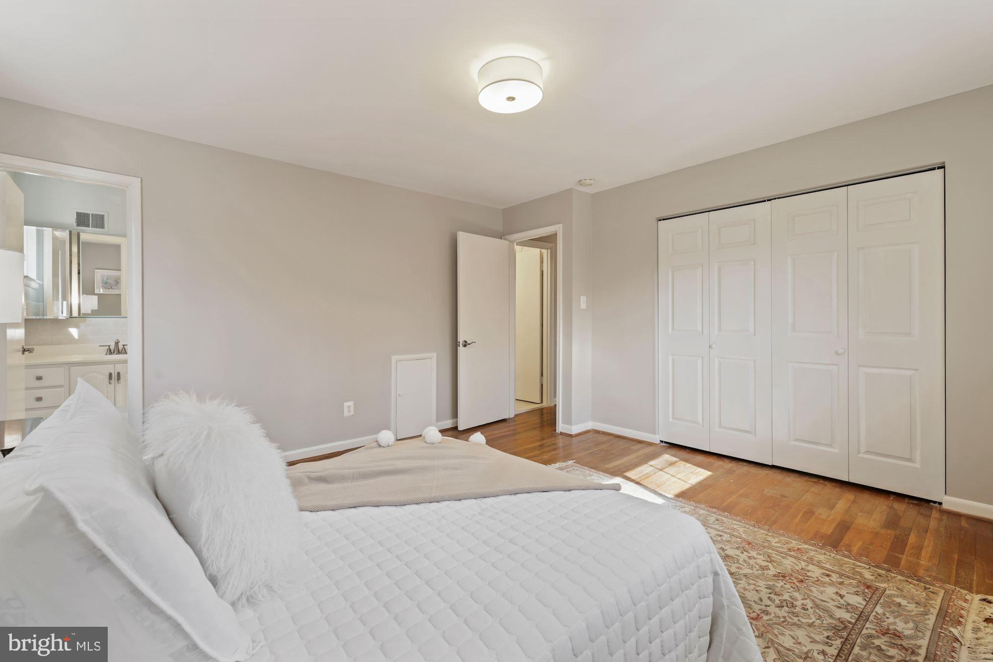 7716 Beech Tree Road Bethesda, MD 20817 - Photo 34 of 49 a bedroom with a bed and a wooden floor