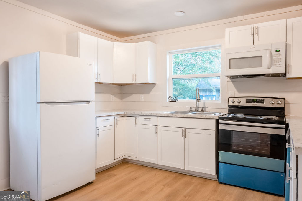 80 Menefee Street Palmetto, GA 30268 - Photo 11 of 30 a kitchen with granite countertop white cabinets and white appliances