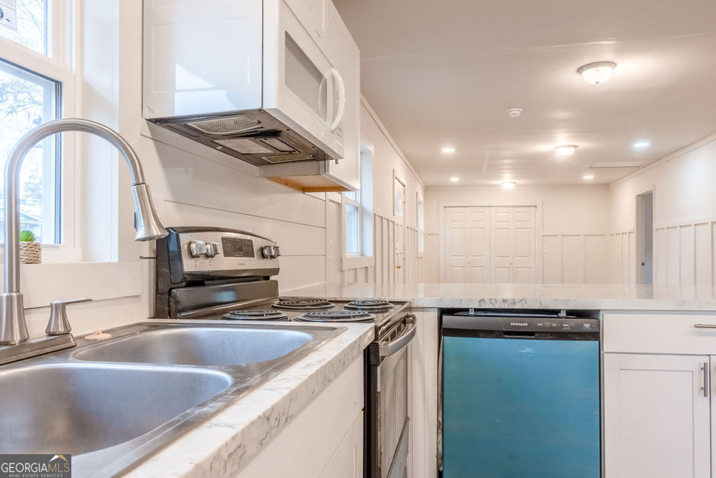 80 Menefee Street Palmetto, GA 30268 - Photo 12 of 30 a kitchen with granite countertop a sink and a stove top oven