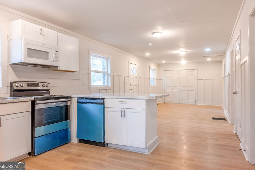 80 Menefee Street Palmetto, GA 30268 - Photo 9 of 30 a kitchen with stainless steel appliances granite countertop a stove and a refrigerator