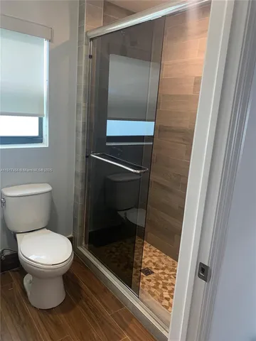 a bathroom with a toilet and a shower