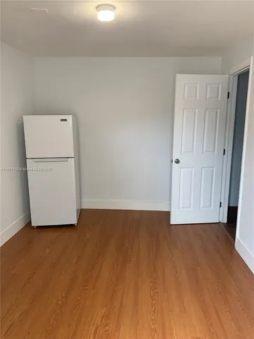 a view of a room with wooden floor and a sink