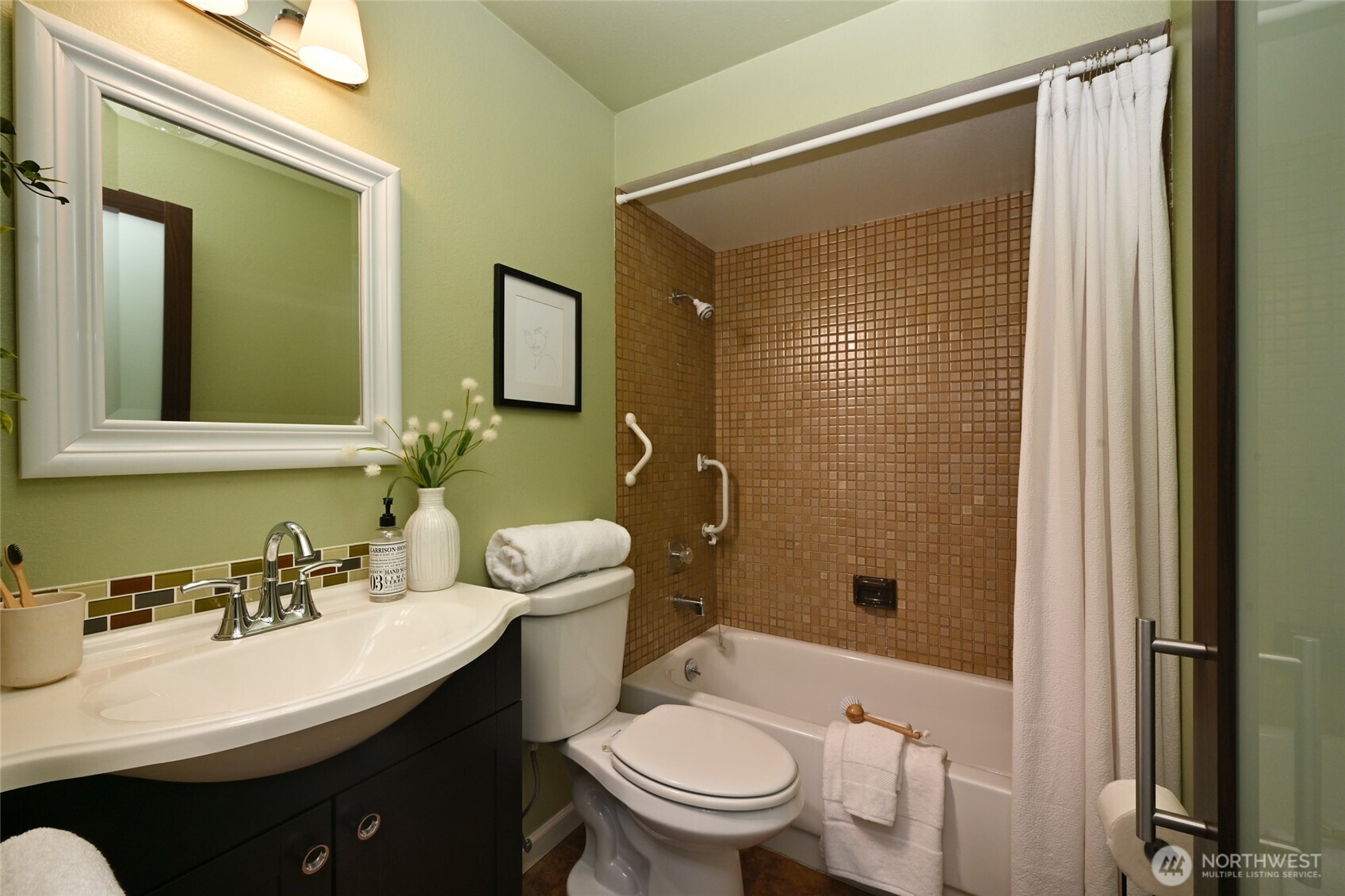 3421 Southwest Roxbury Street, Unit 401 Seattle, WA 98126 - Photo 14 of 22 a bathroom with a sink a toilet a mirror and shower