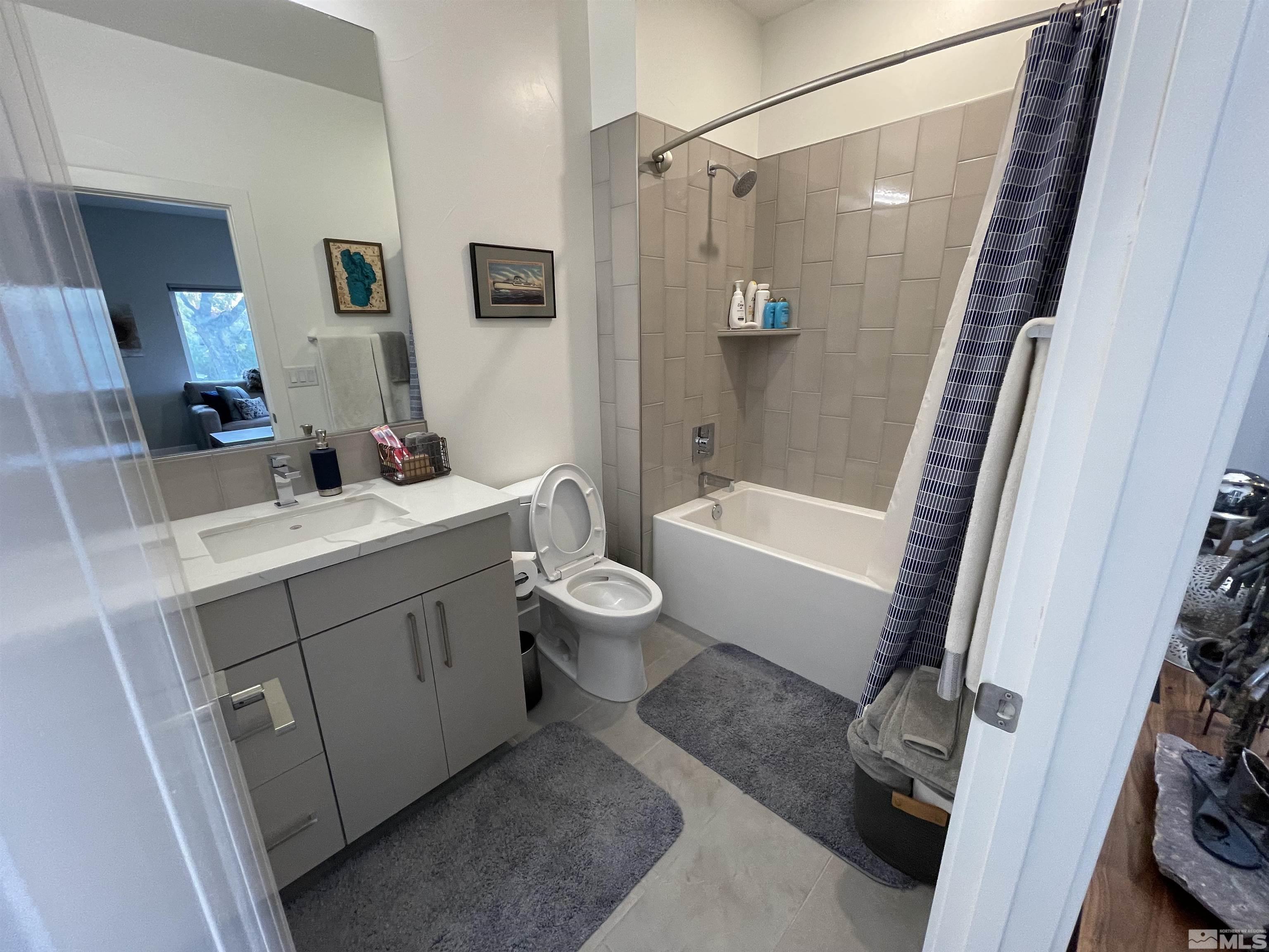 123 Martin Street Reno, NV 89509 - Photo 23 of 31 a bathroom with a sink a toilet a mirror a vanity and shower