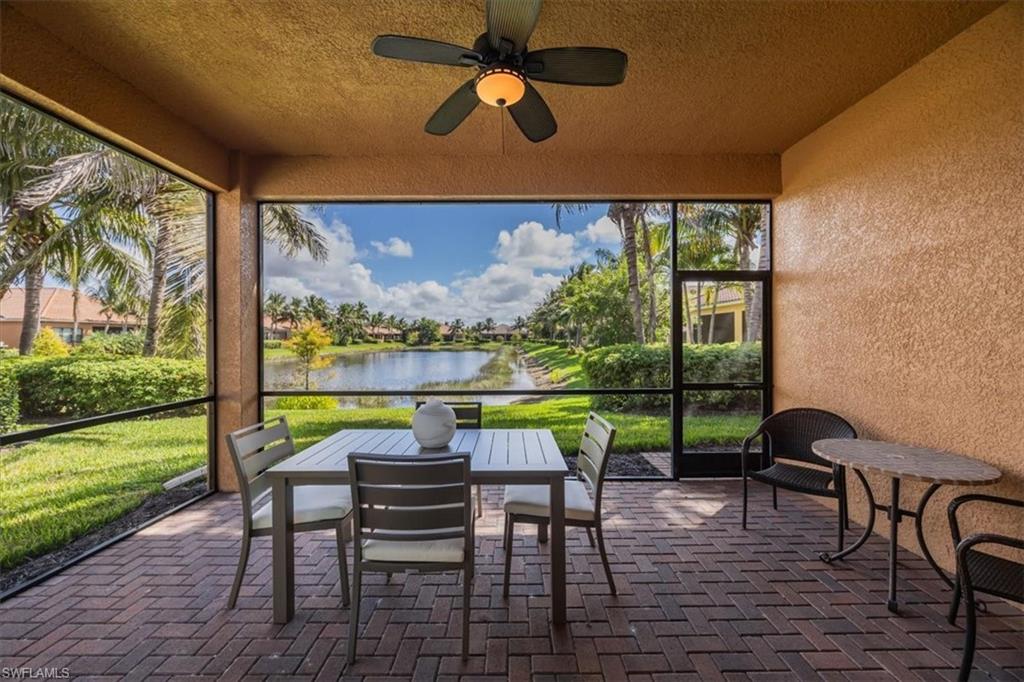 Sunroom / solarium featuring a ceiling fan, a water view, and outdoor dining area