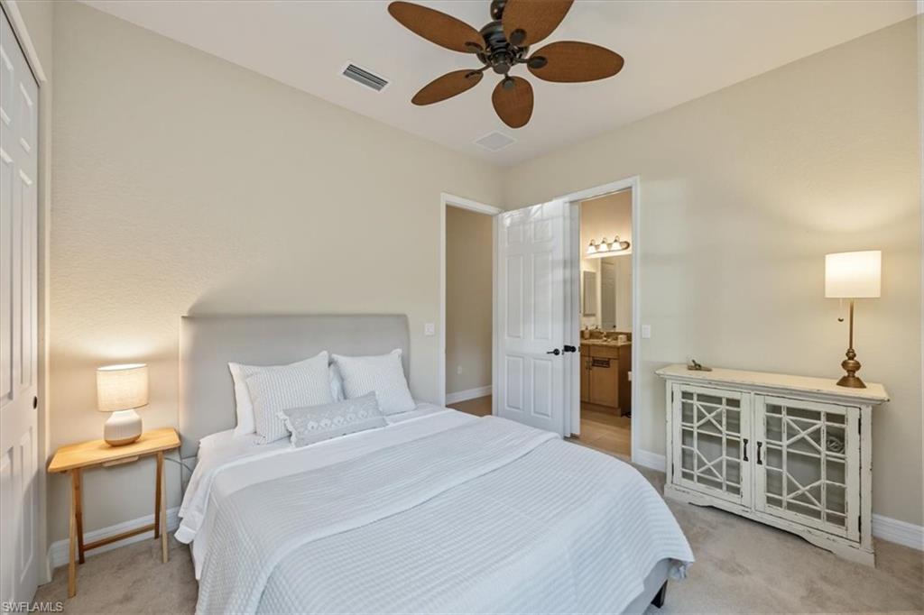 13466 Sumter Lane Naples, FL 34109 - Photo 16 of 36 Bedroom with light colored carpet, a ceiling fan, and ensuite bath