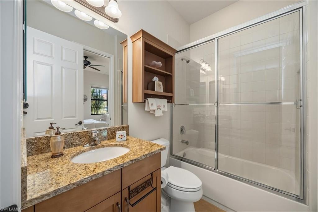 13466 Sumter Lane Naples, FL 34109 - Photo 19 of 36 Bathroom featuring bath / shower combo with glass door, vanity, ensuite bathroom, and a ceiling fan