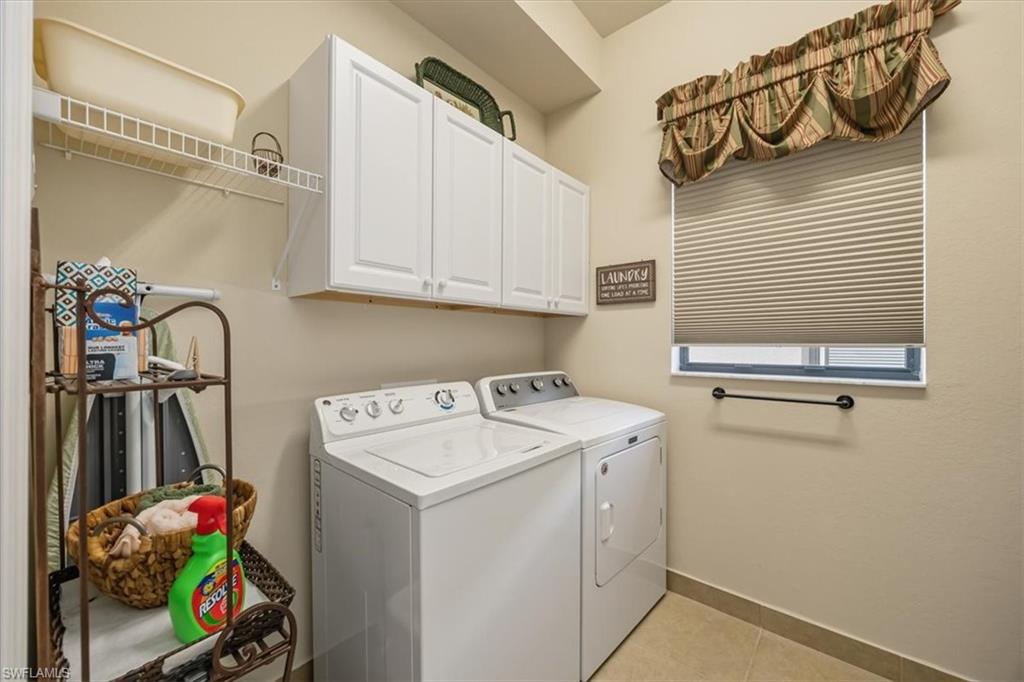 13466 Sumter Lane Naples, FL 34109 - Photo 20 of 36 Laundry room with cabinet space, light tile patterned floors, and washer and clothes dryer