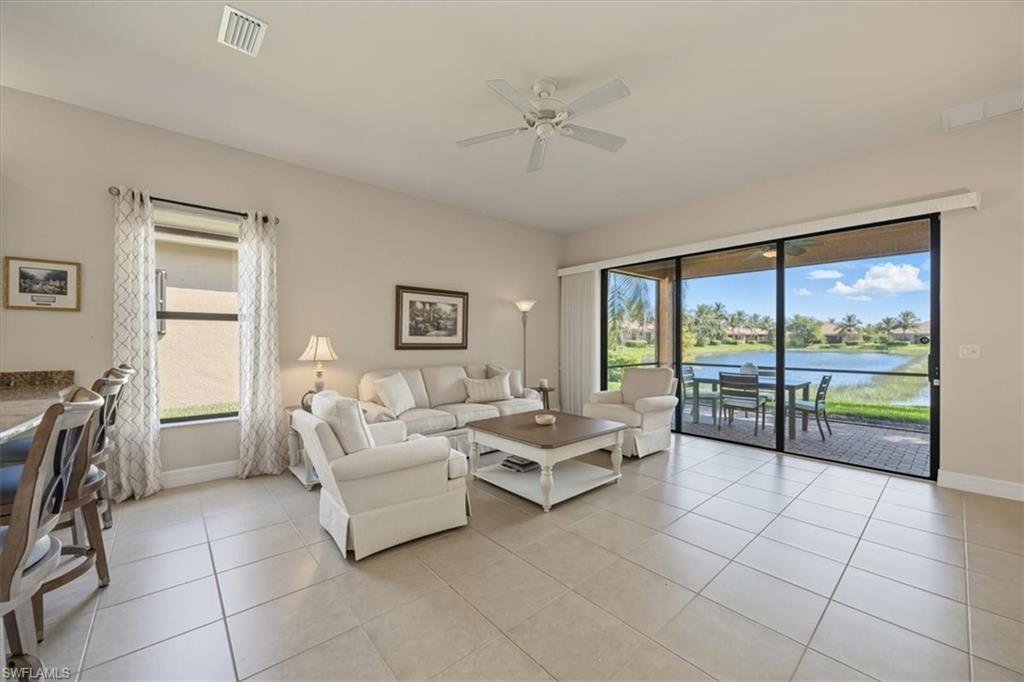 13466 Sumter Lane Naples, FL 34109 - Photo 6 of 36 Living room featuring light tile patterned floors, ceiling fan, and a water view