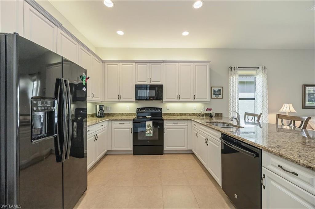 13466 Sumter Lane Naples, FL 34109 - Photo 8 of 36 Kitchen with black appliances, light stone counters, white cabinetry, a peninsula, and recessed lighting