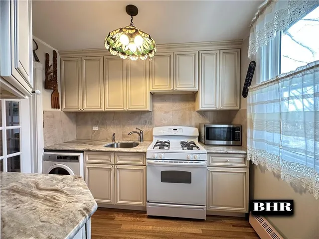 a kitchen with a stove cabinets and wooden floor