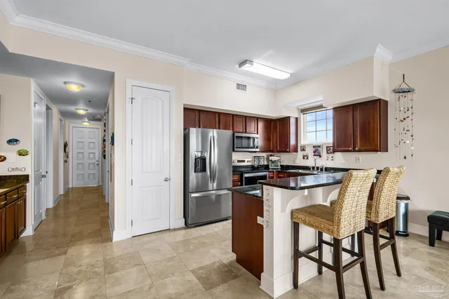 a kitchen with stainless steel appliances granite countertop a refrigerator and a stove top oven