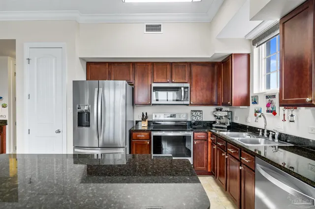a kitchen with stainless steel appliances granite countertop a refrigerator stove and sink