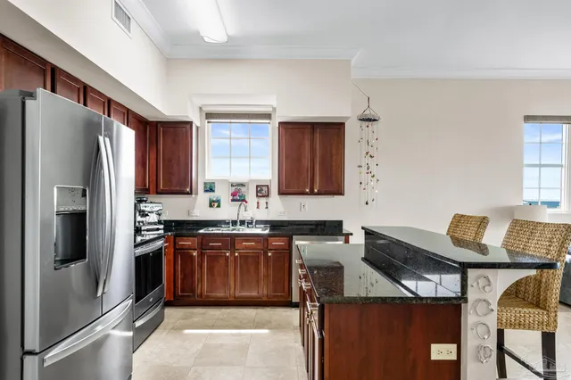 a kitchen with stainless steel appliances granite countertop a refrigerator sink and stove