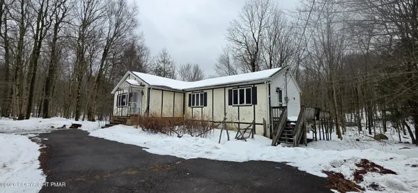 a view of a house with a yard covered in snow
