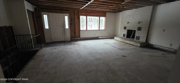 an empty room with fireplace and windows