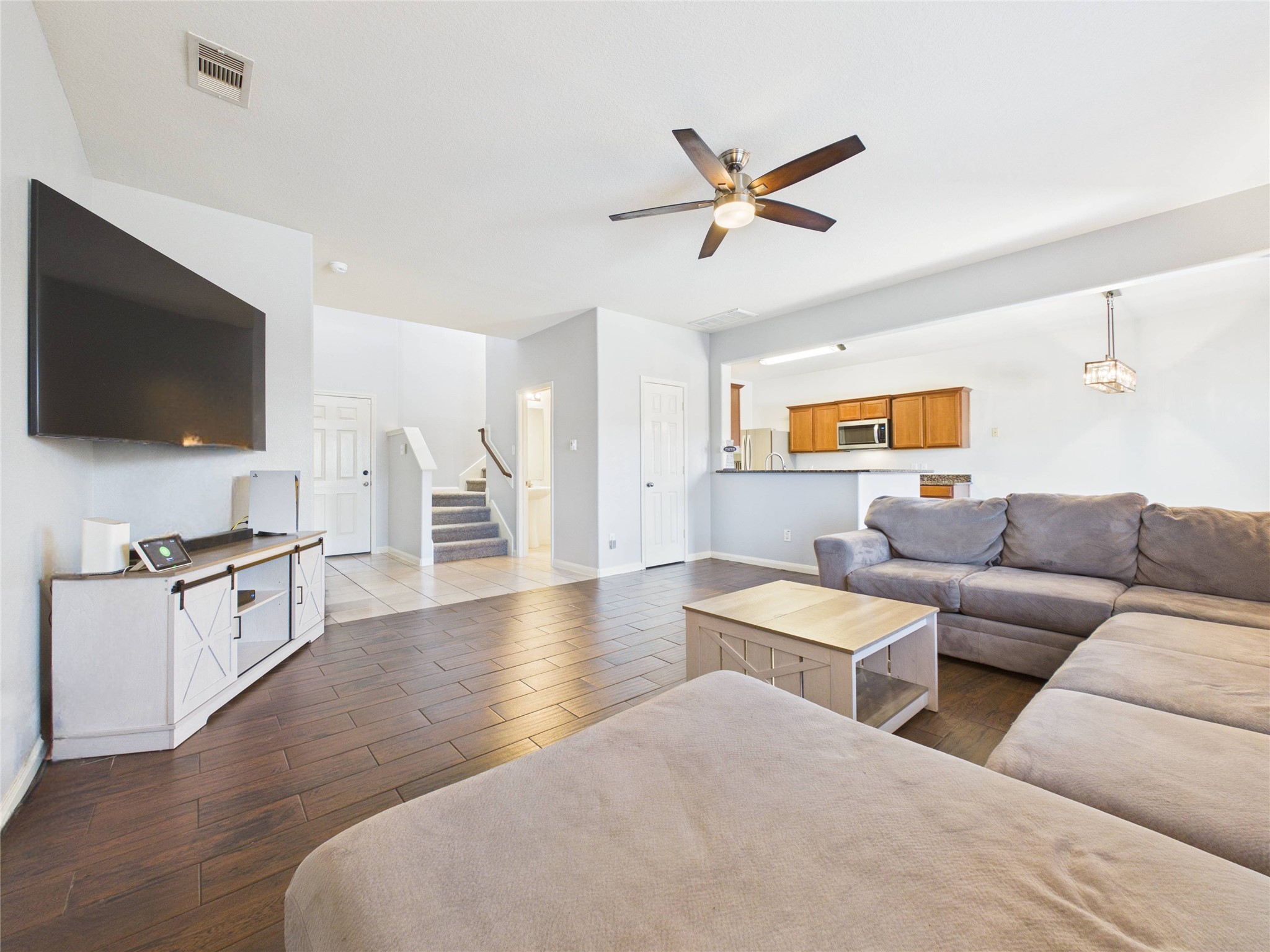911 Marigold Road Baytown, TX 77521 - Photo 11 of 32 The spacious living area with tile floors flows into a well-appointed kitchen featuring wooden cabinets and a breakfast bar.