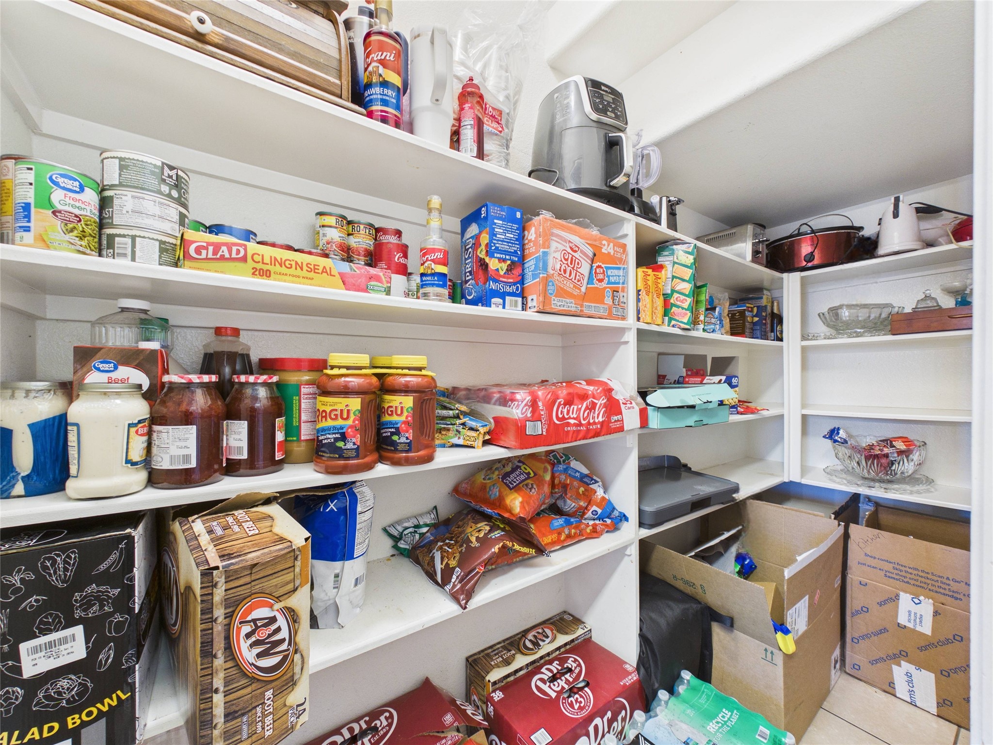 911 Marigold Road Baytown, TX 77521 - Photo 19 of 32 The spacious pantry provides ample storage with multiple shelves, perfect for organizing groceries, appliances, and household essentials.
