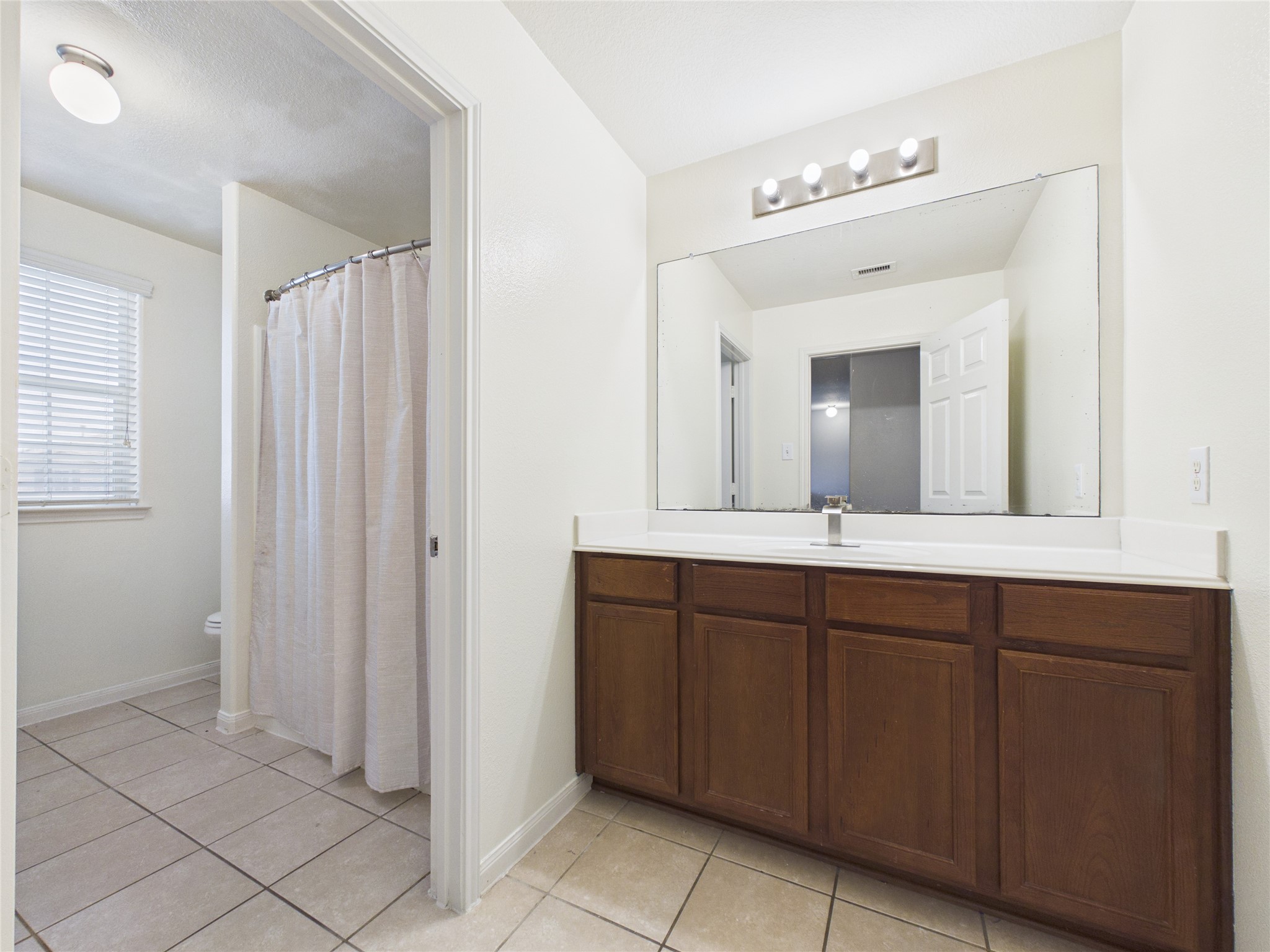 911 Marigold Road Baytown, TX 77521 - Photo 23 of 32 The bathroom features a spacious vanity with a large mirror and ample cabinet storage. The separate shower provides additional privacy.