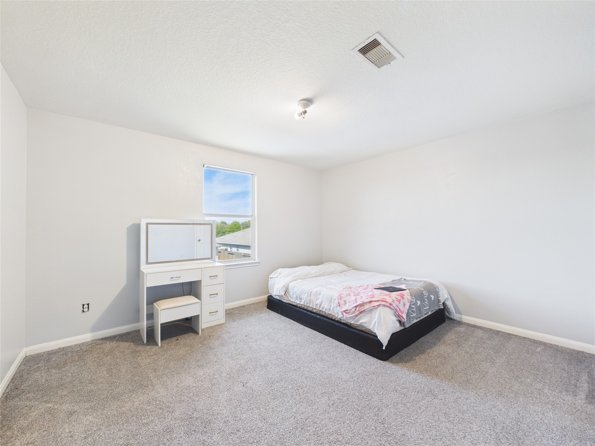 911 Marigold Road Baytown, TX 77521 - Photo 27 of 32 This spacious bedroom features neutral walls and carpeting, a window providing natural light.