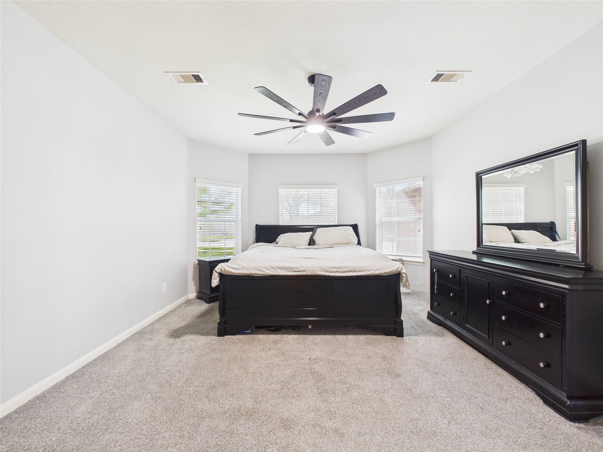911 Marigold Road Baytown, TX 77521 - Photo 5 of 32 This primary bedroom is spacious, features neutral walls, plush carpeting, and ample natural light from multiple windows.