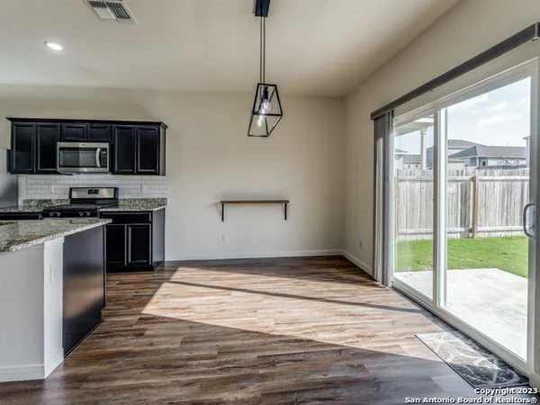 a kitchen with kitchen island granite countertop a stove and a wooden floor