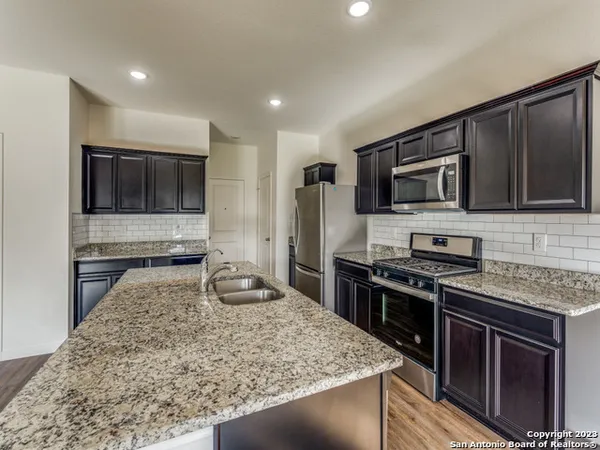 a kitchen with stainless steel appliances granite countertop a stove microwave and sink
