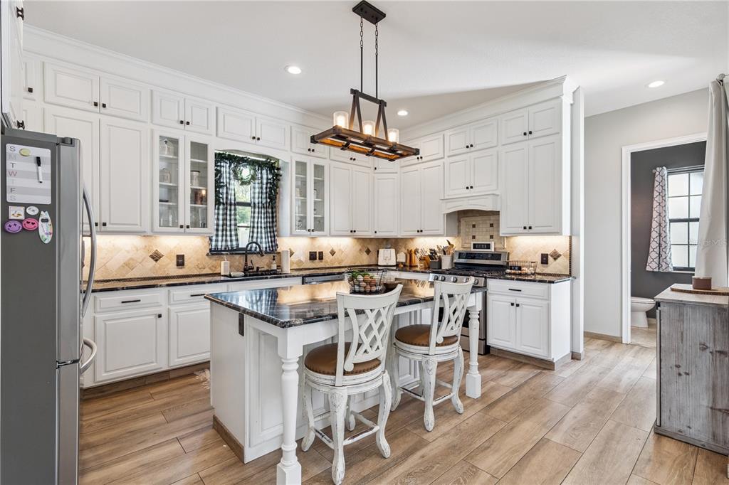 345 Cypress Isles Road Osteen, FL 32764 - Photo 4 of 41 a kitchen with stainless steel appliances a dining table chairs stove and refrigerator