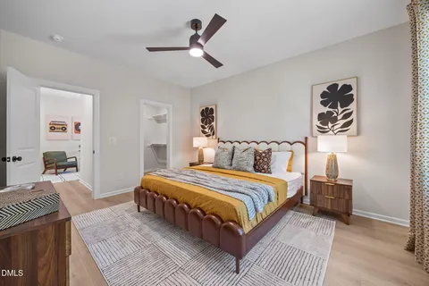 a bedroom with a bed a dresser and next to a window