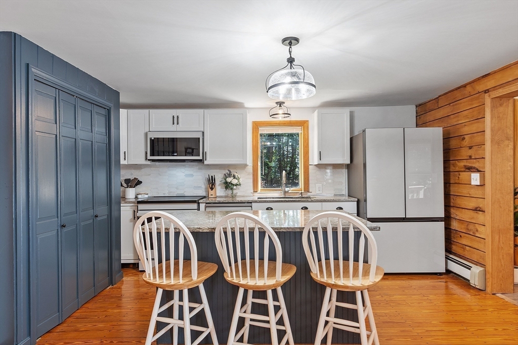 173 Minott Road Westminster, MA 01473 - Photo 4 of 33 a kitchen with stainless steel appliances granite countertop a dining table chairs refrigerator and microwave