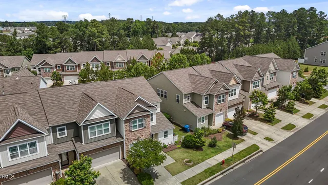 an aerial view of multiple houses with a yard