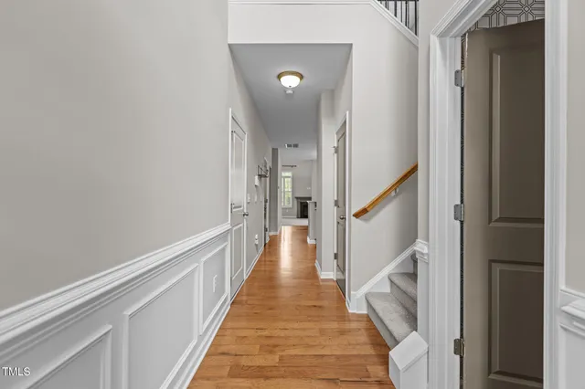a view of a hallway with wooden floor and staircase