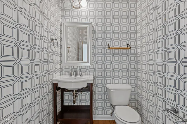 a bathroom with a sink a toilet and mirror