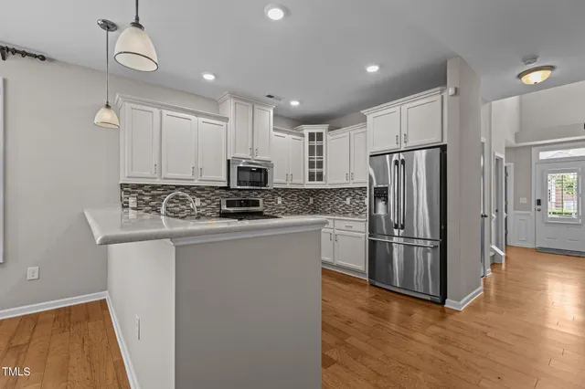 a kitchen with kitchen island white cabinets and stainless steel appliances