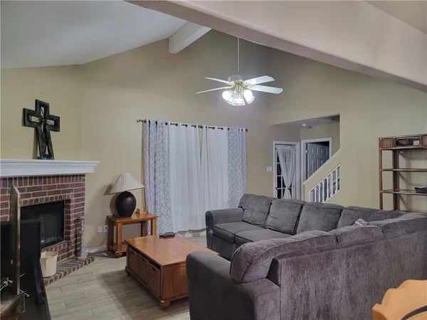 a living room with furniture a fireplace and a chandelier