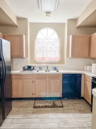 a large kitchen with granite countertop a stove a sink and a refrigerator
