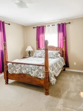 a bed sitting in a bedroom next to a window