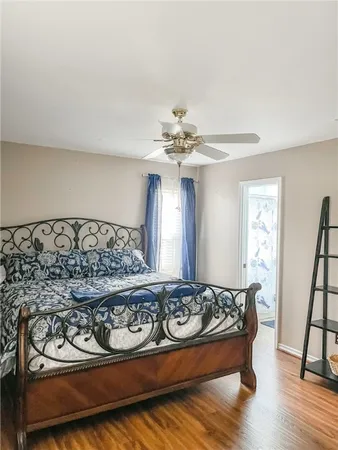 a bedroom with a bed and wooden floor