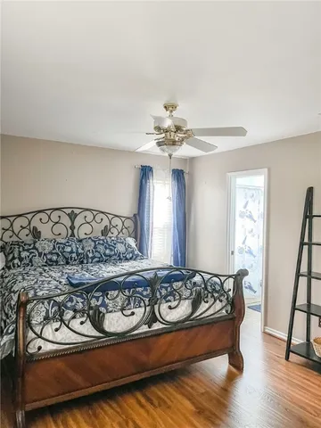 a bedroom with a bed and wooden floor