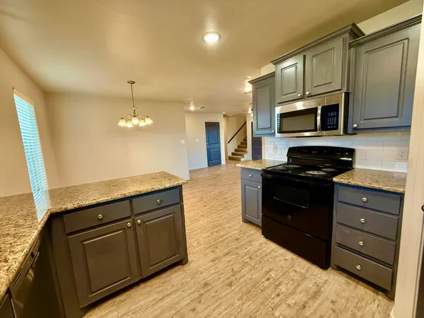 a kitchen with stainless steel appliances granite countertop a refrigerator and a stove top oven