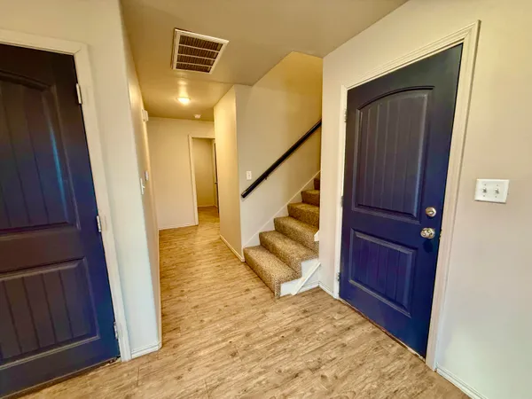 a view of entryway and hall with wooden floor