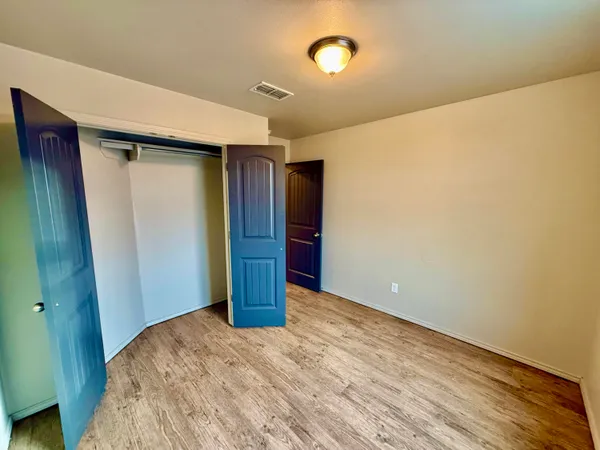 a view of wooden floor and a chandelier fan in a room