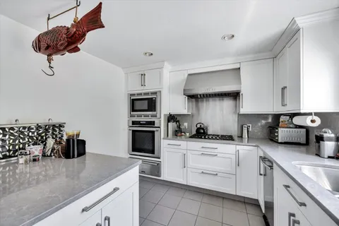 a kitchen with white cabinets and appliances