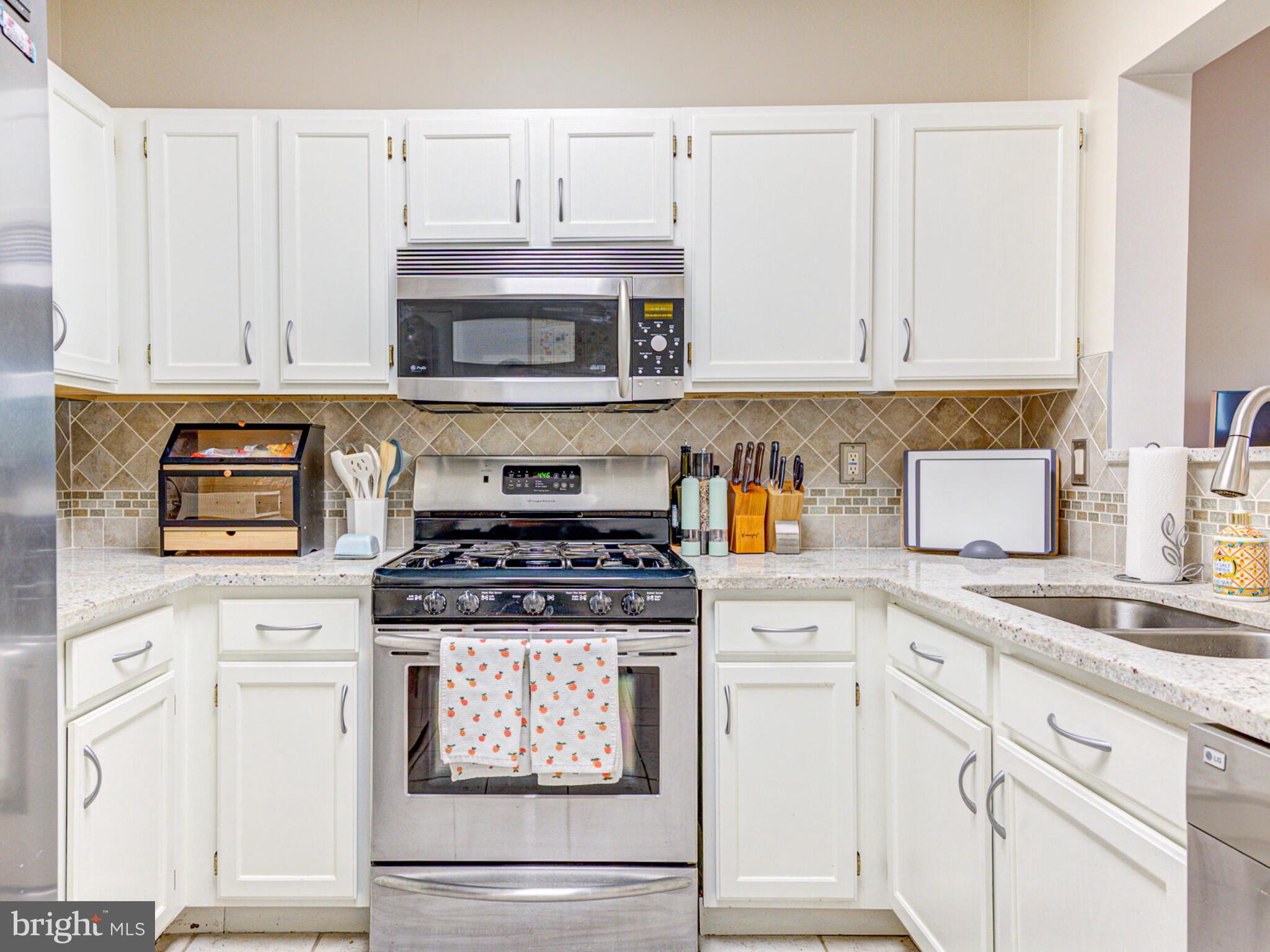1720 Lake Shore Crest Drive, Unit 35 Reston, VA 20190 - Photo 19 of 41 a kitchen with granite countertop white cabinets and white appliances