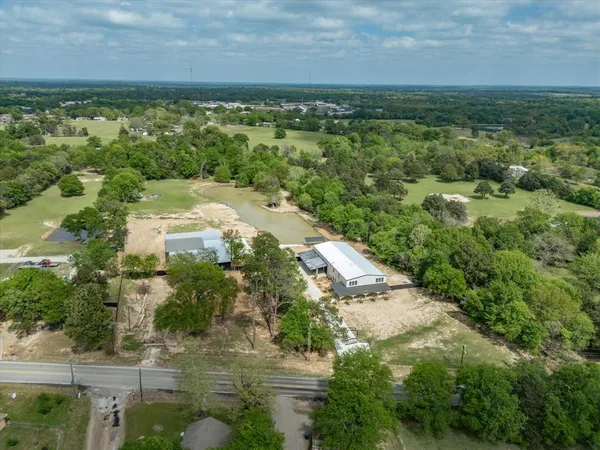 an aerial view of residential houses with outdoor space and trees