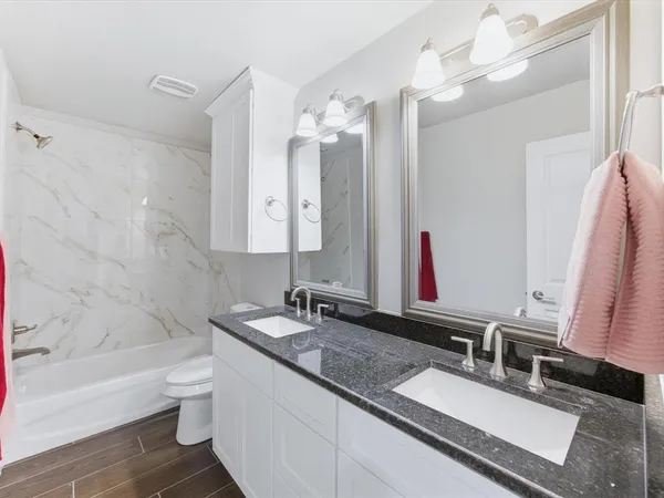 a large white bathroom with a double vanity sink and a mirror