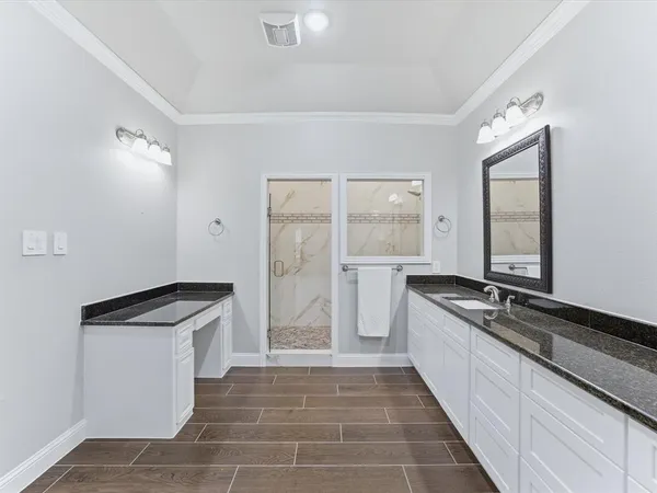 a view of a hallway with bathroom and wooden floor