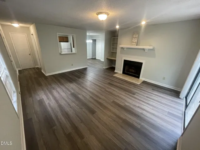 an empty room with wooden floor and a fireplace