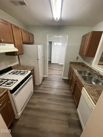 a kitchen with granite countertop a stove and a refrigerator